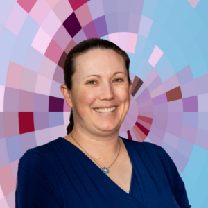 Headshot of Torrey Trust, a smiling white woman with dark hair pulled back, wearing a blue dress and a necklace on top of a MYFest background of colorful pink, purple and blue four-sided shapes spiraling out from the center.