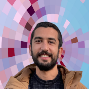 Headshot of Bassem El Bendary, a smiling man with short dark hair, beard, and mustache wearing a dark shirt and tan jacket, on top of a MYFest background of colorful pink, purple and blue four-sided shapes spiraling out from the center.