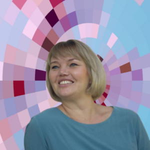 Headshot of Lauren Butler, a smiling woman with medium length blonde hair and bangs wearing a light blue top, on top of a MYFest background of colorful pink, purple and blue four-sided shapes spiraling out from the center.