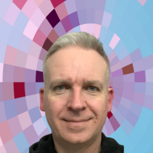 Headshot of Paul Martin, a smiling man with short blonde hair wearing a dark shirt on top of a MYFest background of colorful pink, purple and blue four-sided shapes spiraling out from the center.