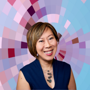 Headshot of Stella Lee, a smiling East Asian woman with medium-length reddish-brown hair wearing a dark blue sleeveless top and a necklace of roundish stones on top of a MYFest background of colorful pink, purple and blue four-sided shapes spiraling out from the center.